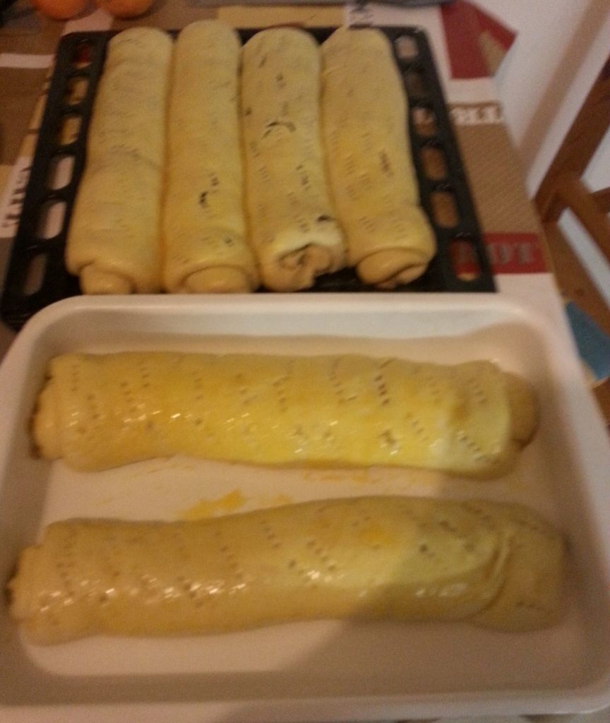 Fél óra elteltével adjuk hozzá a citromot, majd egy fakanál segítségével a tésztát kemény mozdulatokkal erősen keverjük, addig, amíg fényes és levegős nem lesz.
Ezután újabb fél óra kelesztés következik.
Ha már szépen feljött, nyújtsuk ki egy centi vastagra, kenjük meg a kihűlt töltelékkel, majd óvatosan tekerjük fel.