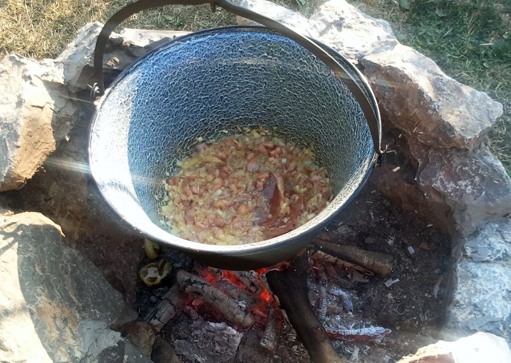 A szalonnát apróra vágjuk, majd kisütjük a zsírját a bográcsban. Amikor a zsír kisült, de még a szalonna sem égett meg, hozzáadjuk az apróra vágott vöröshagymát. 2-3 perc múlva, mehet bele a szintén apróra vágott paprika is. Amikor a pörkölt alap szépen összesül, hozzáadjuk a megmosott 2-3 cm-es darabokra vágott csülök húst és megpróbáljuk összekeverni a hagymával.