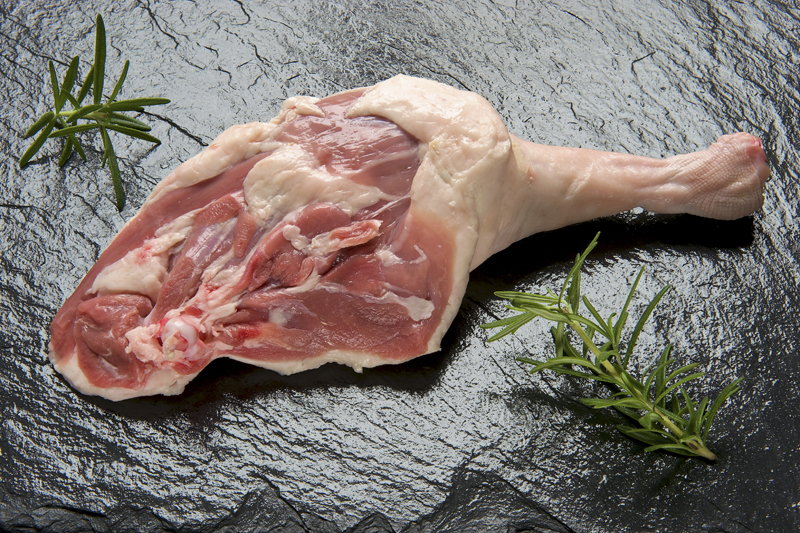 A fokhagymát vágjuk kis darabokra, az almát mossuk meg, és negyedeljük fel. A libacombokat tisztítsuk, mossuk meg, majd töröljük jó szárazra. Alaposan dörzsöljük be sóval, szórjunk rá borsot és majoránnát. Egy magasabb falú tepsit kenjünk ki kevés libazsírral, és rendezzük el benne a húst úgy, hogy a bőrös fele legyen lefelé. Rakjuk a combok mellé az almát és a fokhagymát, majd fedjük le.