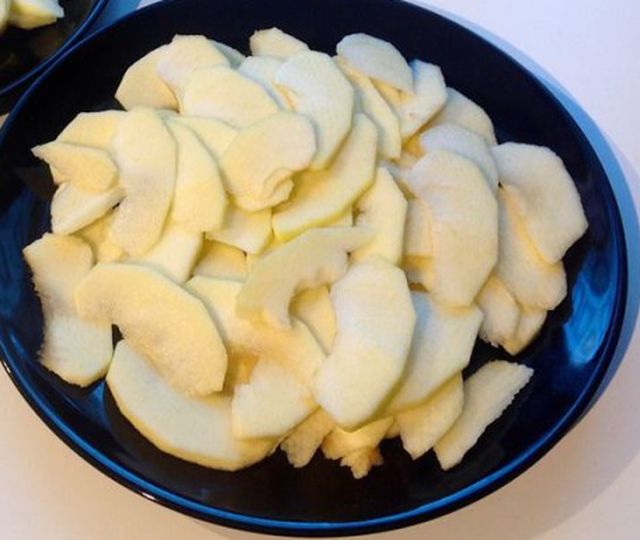 A többi almát vágjuk fel vékony szeletekre. Öntsük a tésztát egy kivajazott, lisztezett kerek formába, majd körben rendezzük el a tetején az almákat.