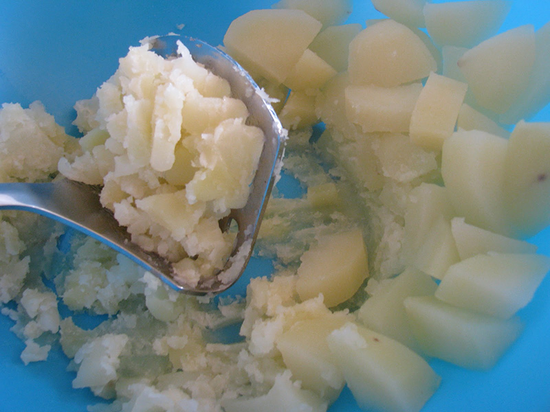 Ez elegendő idő ahhoz, hogy elkészítsük a burgonyagombócot. Ehhez a kihűlt krumplit, a liszttel meg a tojással összegyúrjuk, megsózzuk, megborsozzuk. Vizes kézzel apró gombócokat formálunk belőle és a félpuha zöldségekhez, a forró levesbe rakjuk. További kb. 15 percig főzzük, míg minden meg nem puhul benne.