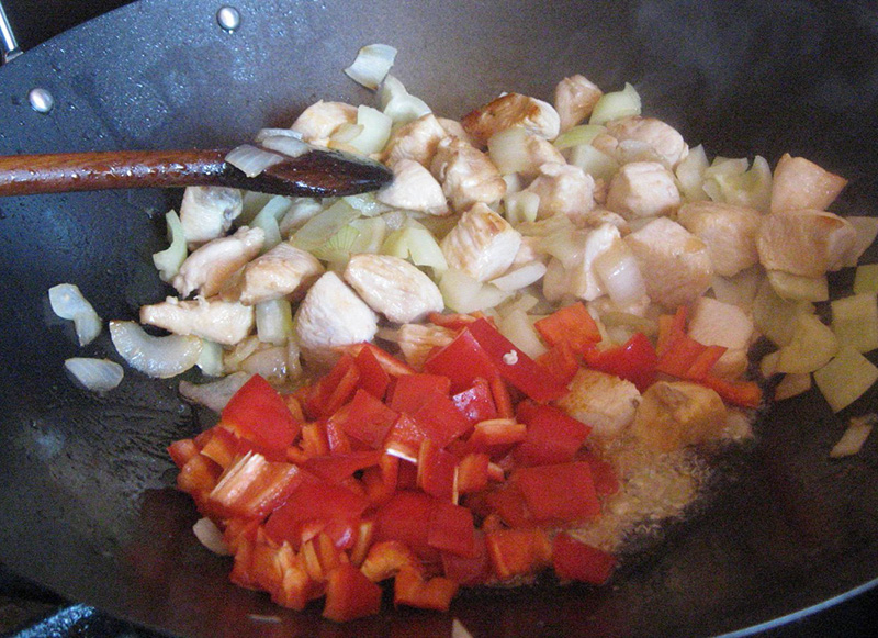 Hozzáadjuk a szintén nagy kockára vágott hagymát, majd a hasonlóan felkockázott paprikát és addig dinszteljük együtt míg a zöldségek széle kissé megpörkölődik, de a közepe roppanós marad.