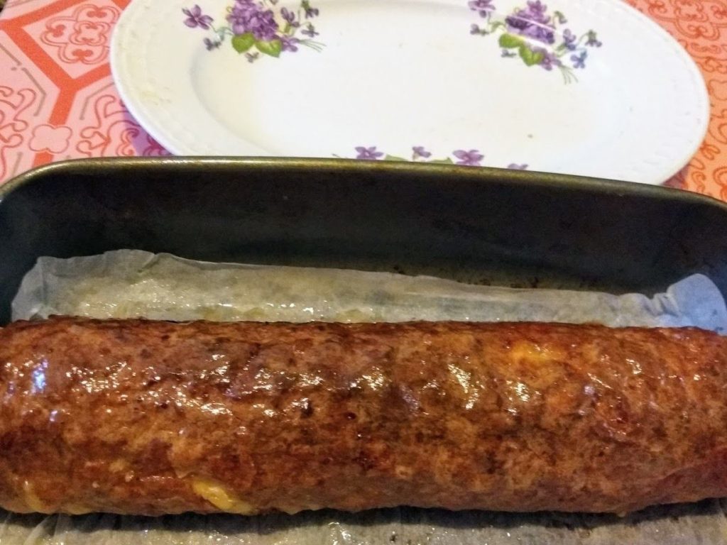 A fólia segítségével feltekerjük és zsírozott tepsibe tesszük. Természetesen a fóliát eltávolítjuk. Használhatunk sütőpapírt is.