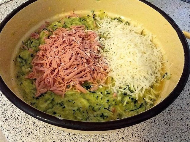 A cukkinit megmossuk, legyaluljuk héjástól, megsózzuk, 10-15 percre félretesszük, majd kinyomkodjuk a levét. Egy tálban összekeverjük a tojással, a zúzott fokhagymával, az aprított petrezselyemmel, hozzáadjuk a sajtot, felvágottat, és annyi zsemlemorzsát, hogy a masszánk formázható legyen.