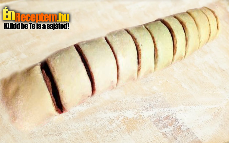 Ezután szorosan feltekerjük. 2 cm-s szeletekre vágjuk.
Sütőpapírral bélelt tepsibe rakjuk a szeleteket, egymás mellé. Nem hagyunk köztük helyet. A másik tésztával ugyanezt megcsináljuk, abba a fahéjas cukrot szórjuk. Előmelegített sütőben, közepes hőfokon addig sütjük, míg a csigák teteje megpirul. Amikor kicsit kihűltek a csigák, meghintjük a tetejüket porcukorral.