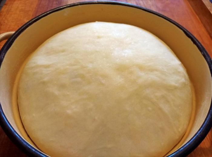 A duplára kelt tésztánkat kb. 35 cm-es kerekre kinyújtjuk, és megkenjük a mascarponeval (vagy krémsajttal).