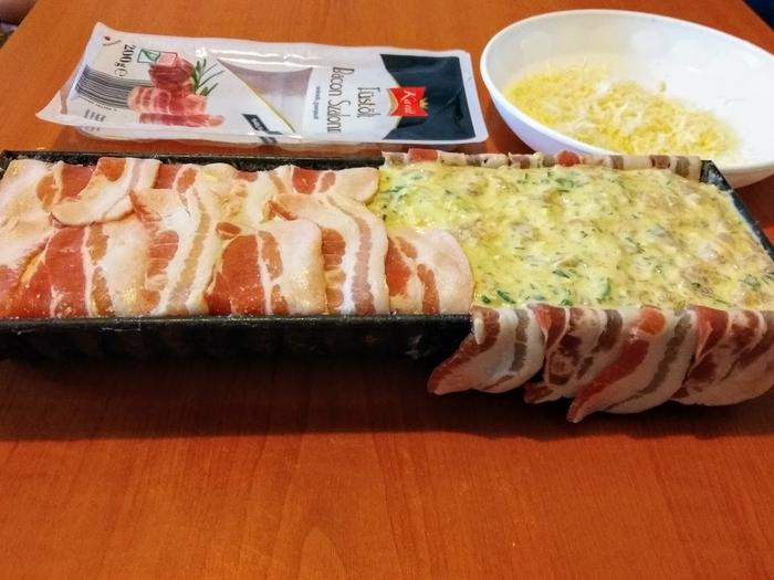 Az őzgerincformát kizsírozzuk, megszórjuk zsemlemorzsával (a biztonság kedvéért) és kibéleljük baconnel úgy, hogy a szélei kilógjanak a formából.