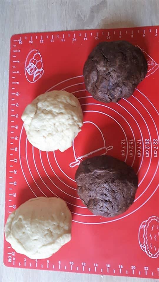 A tejből egy keveset felmelegítünk, amiben leáztatjuk az édesítőket hogy jól feloldódjon.
A maradék tejet 1 evőkanál cukorral meglangyosítjuk, és megkelesztjük az élesztőt benne.
A kakaópor és a vaníliás cukor kivételével jól összedolgozzuk a tésztát, majd elfelezzük. Egyik felébe 2 evőkanál kakaóport, a másikba vaníliás cukrot teszünk.
Majd a kakaós és vaníliás tésztát is elfelezzük.